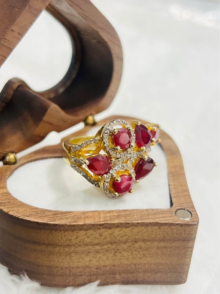 Close-up of a certified vintage-inspired ruby and diamond sterling silver ring in a unique heart-shaped wooden box.