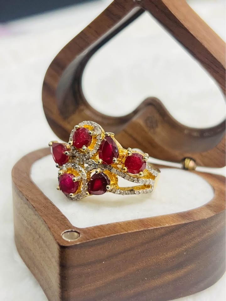 Side view of a certified vintage-inspired ruby and diamond sterling silver ring resting in a heart-shaped box.