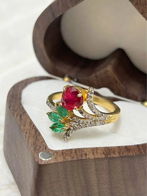 Close-up of a stunning natural ruby, emerald, and diamond ring, showcasing its intricate floral design.