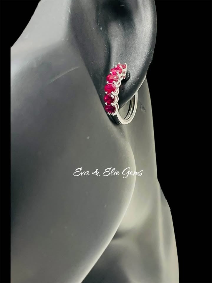 Close-up of a natural ruby huggie hoop earring on a black mannequin, highlighting the vibrant rubies.