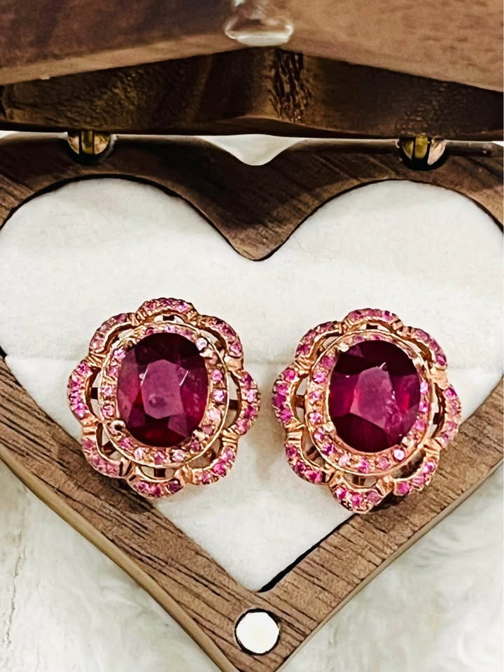 Luxurious ruby and pink sapphire earrings displayed in a charming heart-shaped wooden box.