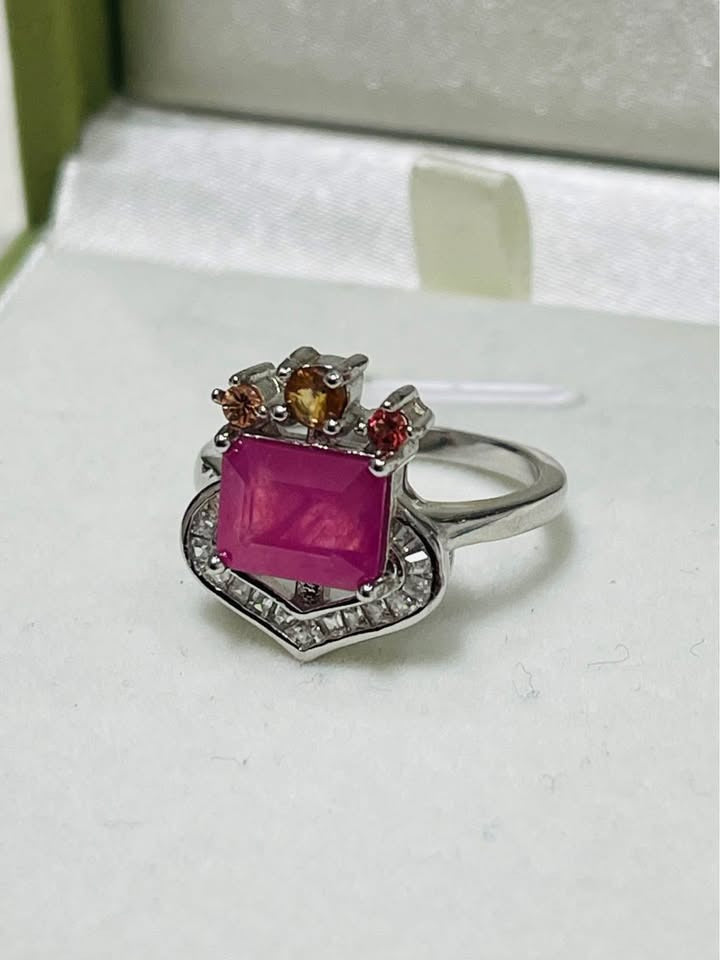 Side angle of a stunning 3 carat natural ruby and colored sapphire ring in a jewelry box.