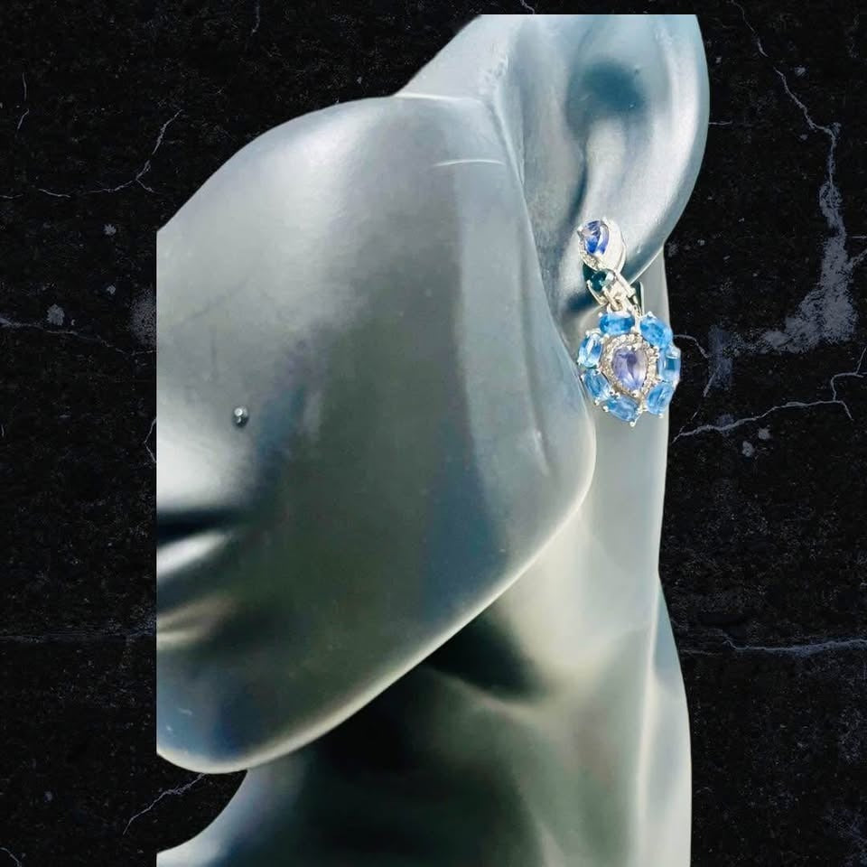 A stunning handmade sapphire and iolite dangle earring showcased on a mannequin's ear against a dark background.