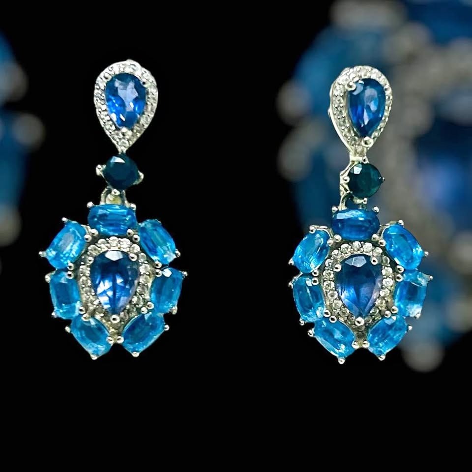  Striking handmade sapphire and iolite dangle earrings with intricate detailing, set against a sleek black background.
