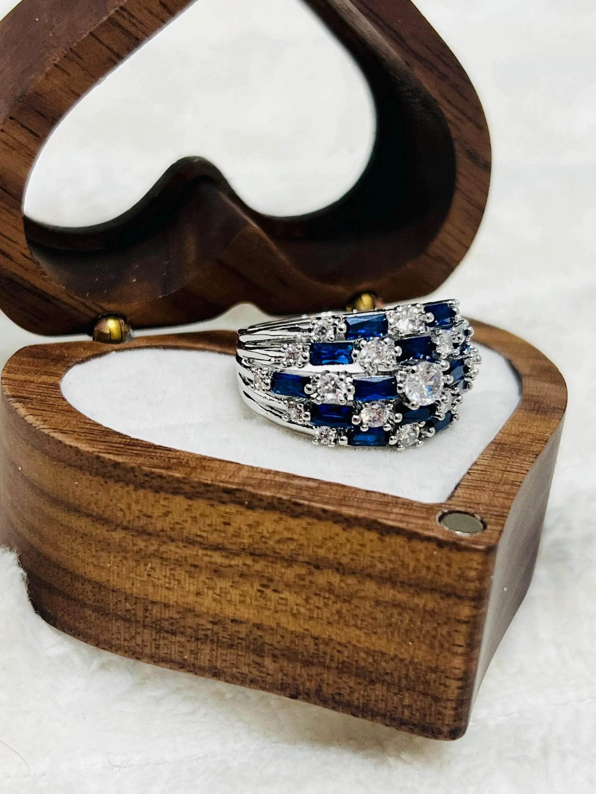  Stunning vintage-inspired sapphire and white stone statement ring, presented in a heart-shaped wooden box.