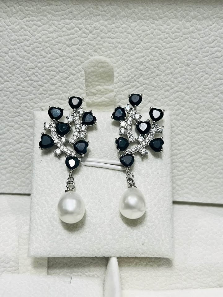 Elegant sterling silver earrings with a branch design of natural sapphires and lustrous pearl drops.