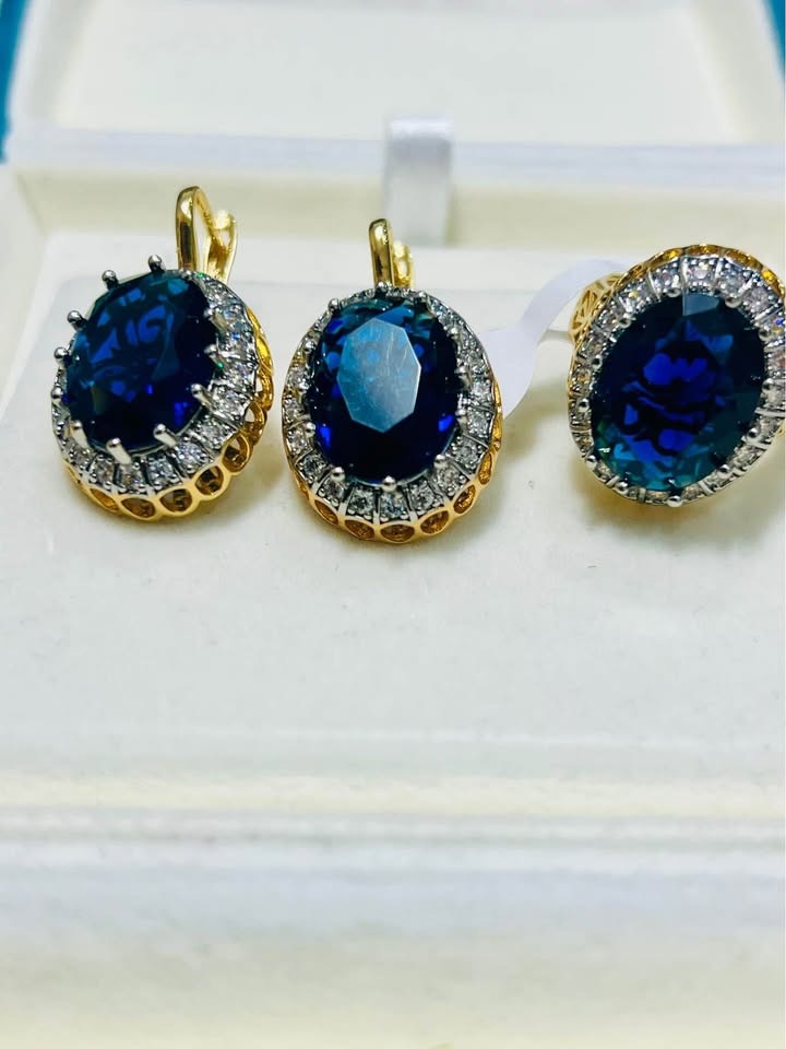  Stunning blue sapphire and diamond halo earrings and ring set, beautifully displayed in a white box.