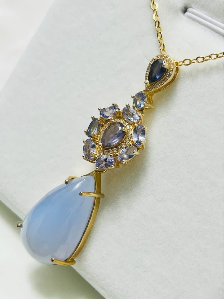  Side view of a 28 ct natural tanzanite and blue sapphire 2-in-1 pendant with pear drop.