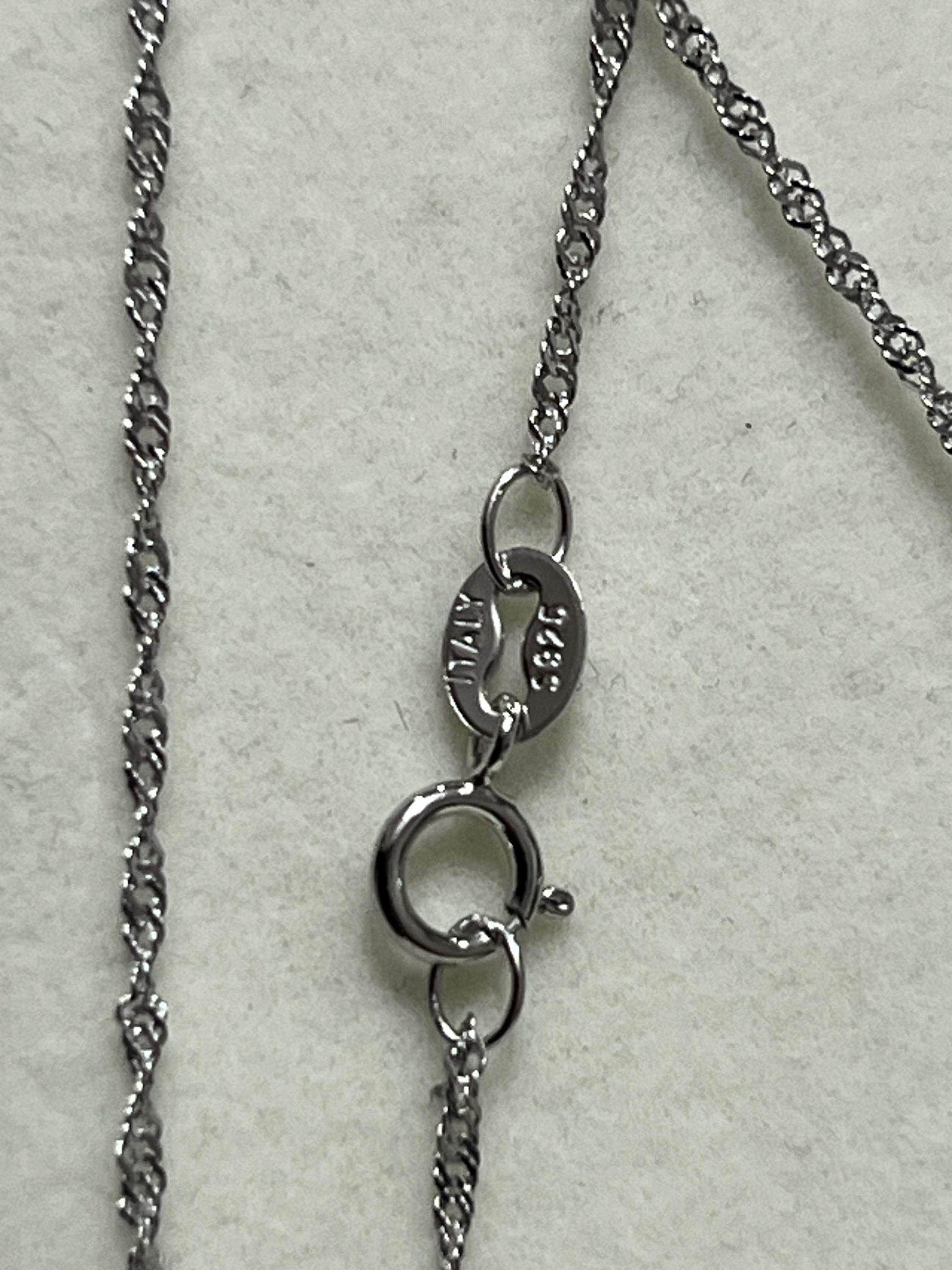  Close-up of a sterling silver (925) chain with an "ITALY" stamp on the clasp, indicating origin.