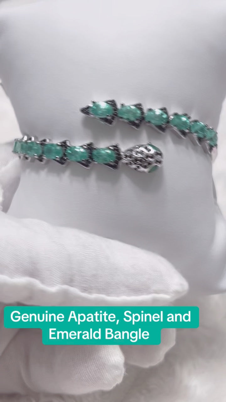 Genuine Apatite, Spinel, and Emerald Bangle on a white cushion