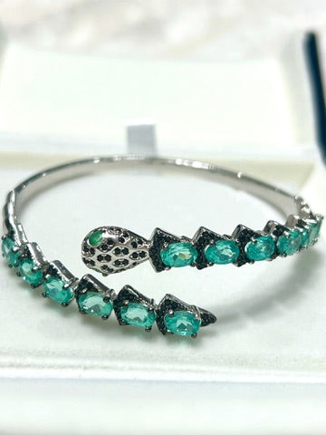 Silver snake head bracelet with apatite and Spinel gemstones  Zoom on a white surface
