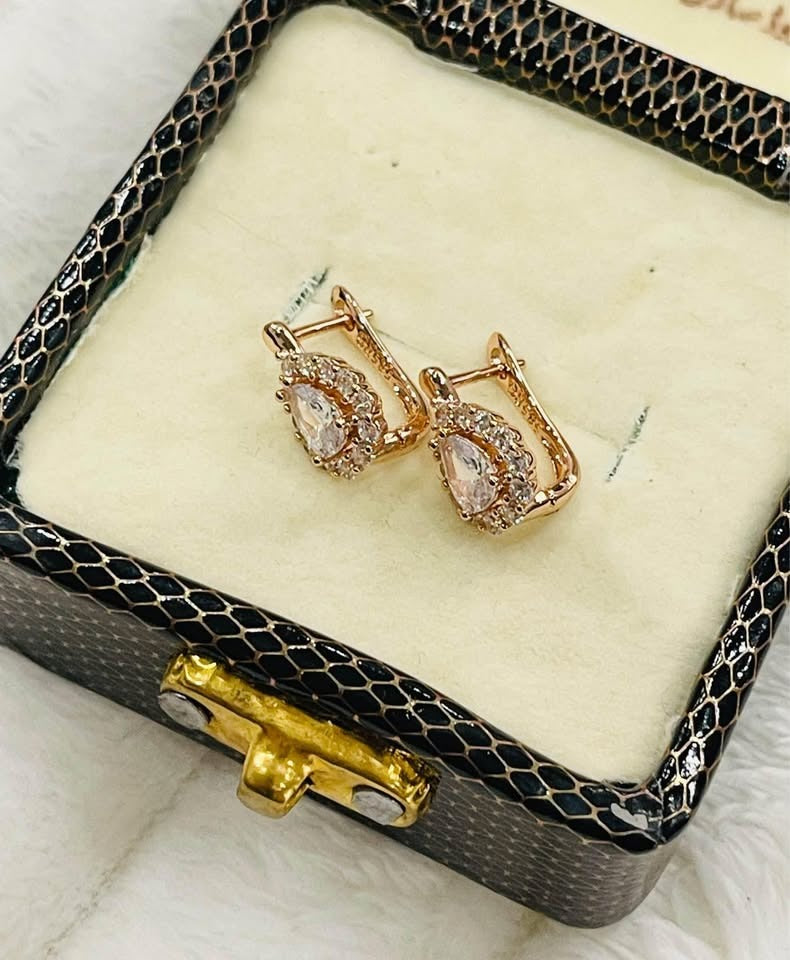 Elegant small 14k gold-plated earrings with white halo stones, displayed in a decorative jewelry box.