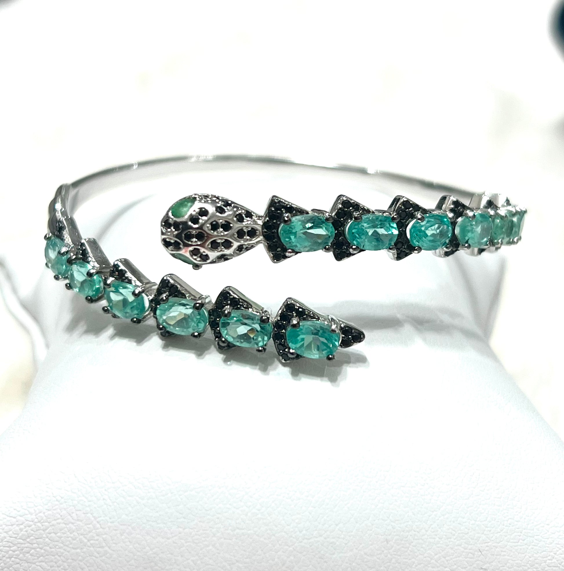 Silver snake head bracelet with apatite and Spinel gemstones on a white background