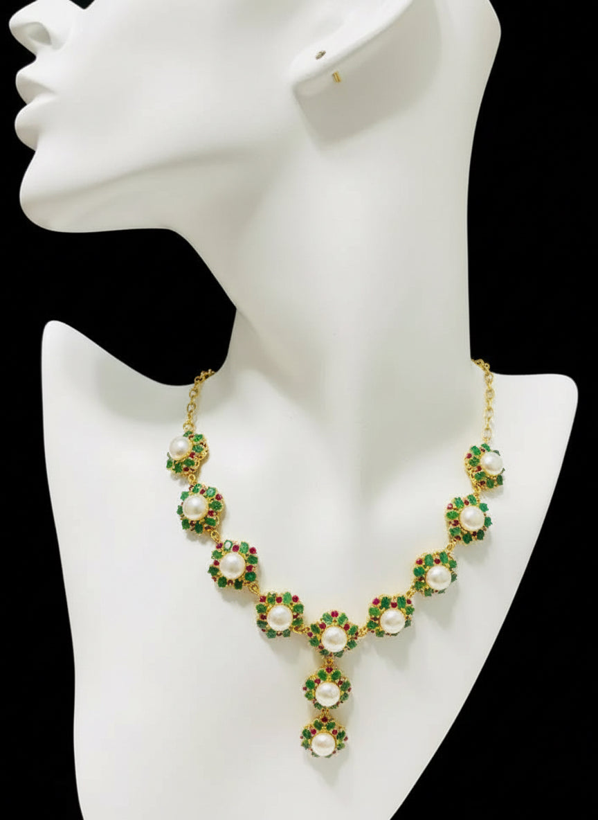 Exquisite South Sea pearl, Colombian emerald, and ruby necklace displayed on a black mannequin.