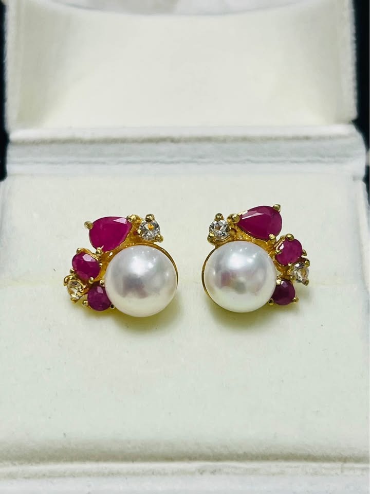 Exquisite artisan South Sea pearl earrings, adorned with vibrant ruby and sparkling white topaz gemstones.