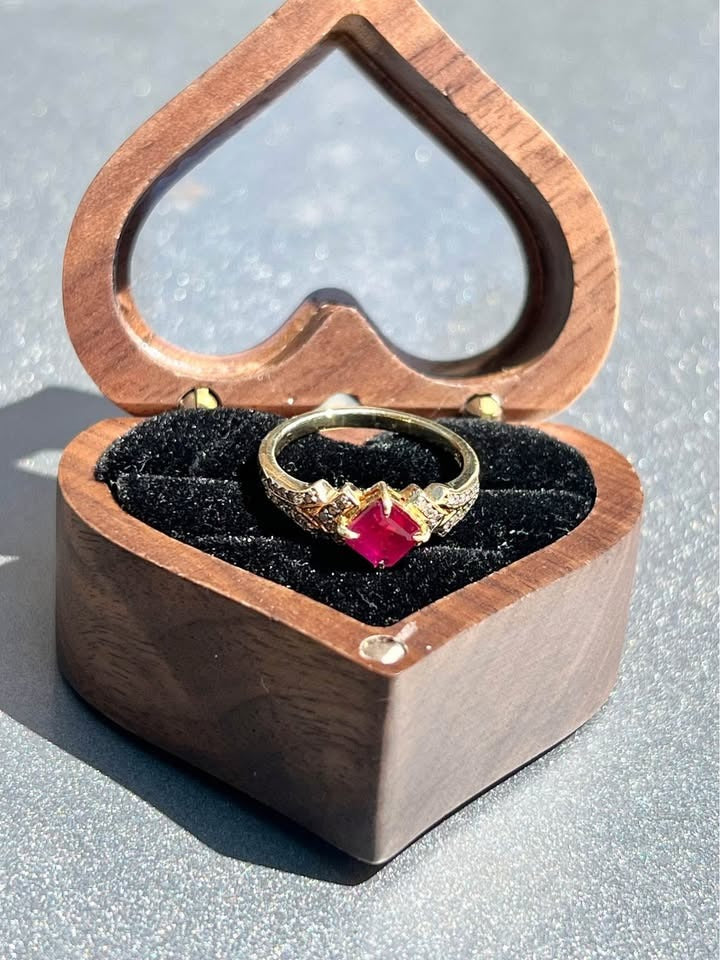 Square cut natural ruby and diamond ring in a heart-shaped box.
