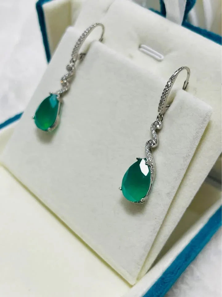  A pair of sterling silver earrings with natural green agate, presented in a white and blue jewelry box.