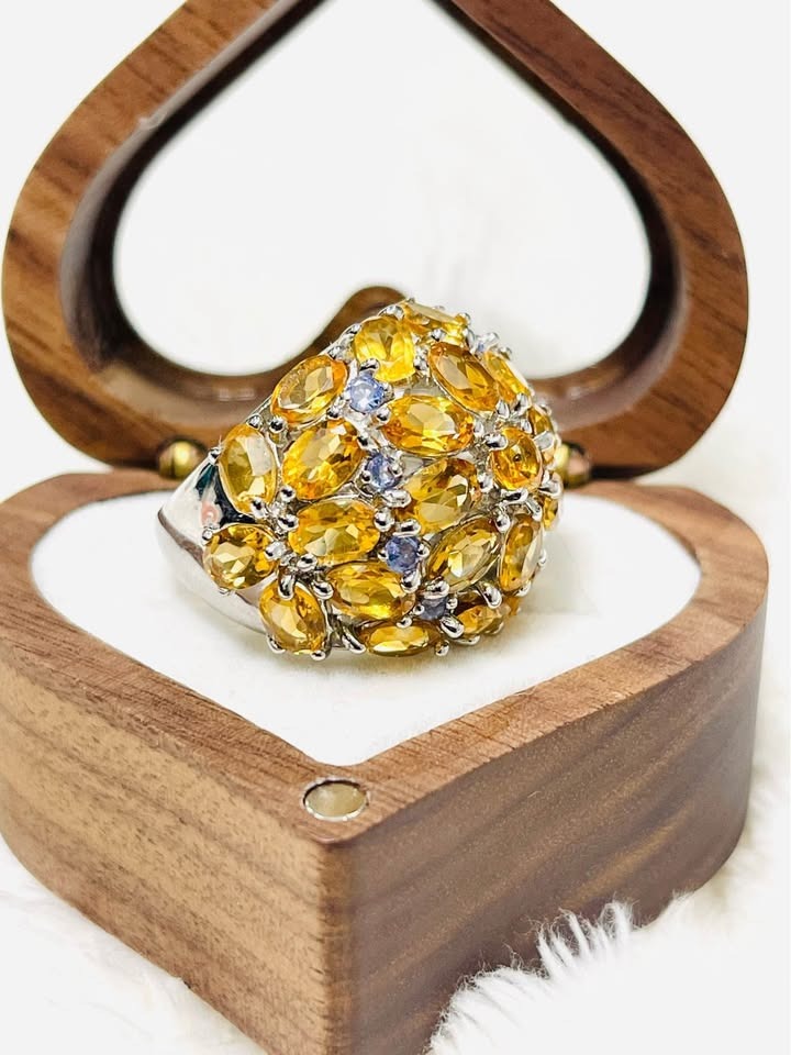  Angled view of a sterling silver ring with a domed design, showcasing brilliant citrine and accent tanzanite stones