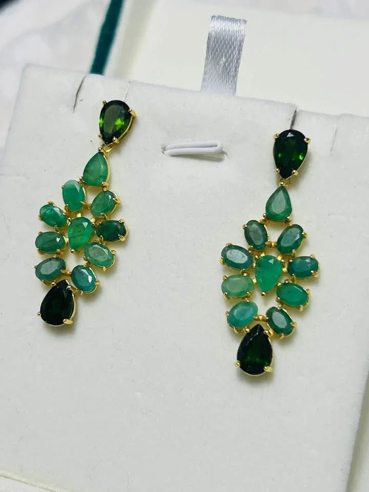 Full view of gorgeous sterling silver chandelier earrings with a cascade of natural emeralds in a unique dropside design.