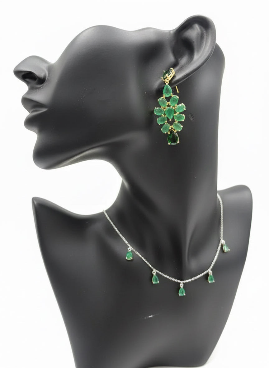 Dropside chandelier earrings on a mannequin, showcasing natural emeralds and dark green gems in a sterling silver setting.