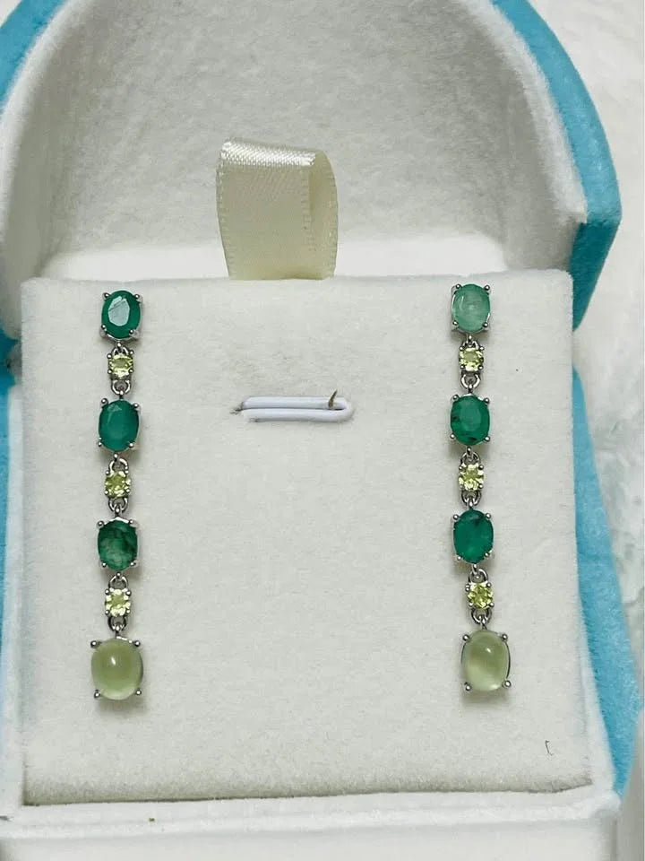 Natural sterling silver earrings with emerald, peridot, and prehnite gems in a blue velvet box.