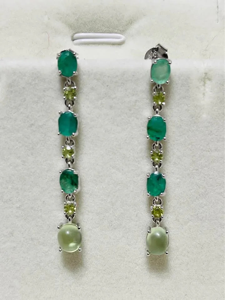 Close-up of natural emerald, peridot, and prehnite dangle earrings showcasing the detailed setting.
