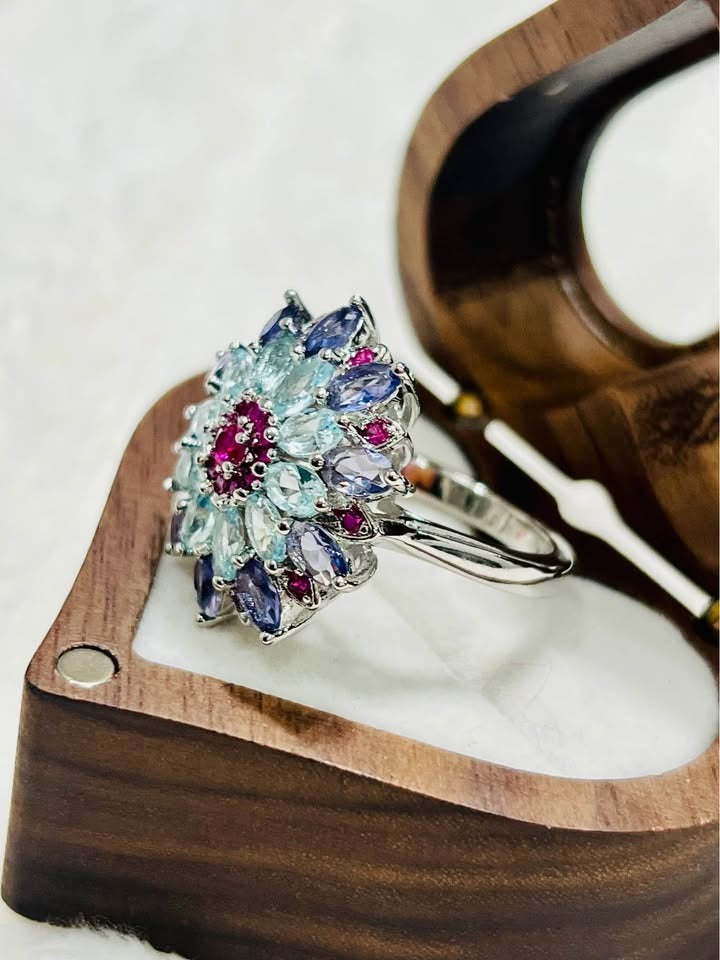 Angled side view of the sterling silver floral ring, highlighting the multi-gemstone cluster design and band.