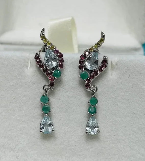 Pair of elegant sterling silver earrings featuring natural aquamarine, emerald, and garnet gemstones.