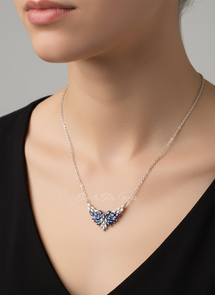 An angled view of a sterling silver necklace with a sparkling natural sapphire pendant, highlighting its elegant design.
