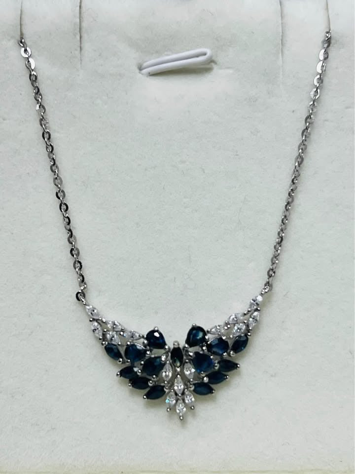 A natural sterling silver sapphire necklace with a stunning multi-stone pendant, isolated on a white background.