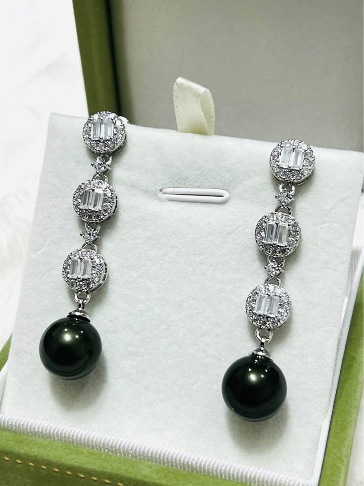 Sterling silver dangle earrings with 10mm peacock Tahitian pearls, surrounded by baguette and cubic zirconia