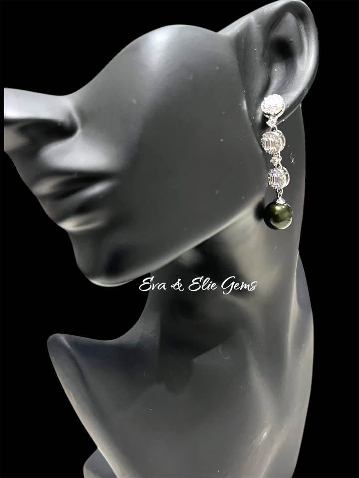 Sterling silver dangle earring on a black jewelry mannequin, featuring a 10mm peacock Tahitian pearl and CZ accents.