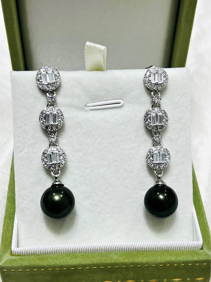 A pair of elegant sterling silver earrings with peacock Tahitian pearls and brilliant CZ accents in a green gift box.