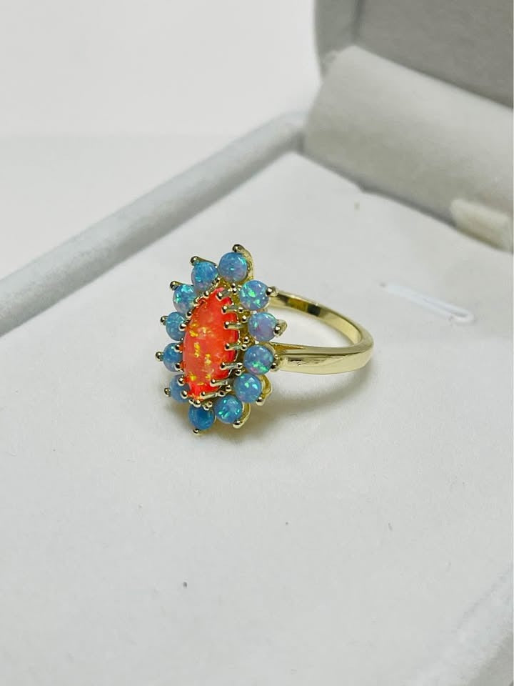  Elegant sterling silver ring showcasing a prominent orange opal framed by smaller blue opals.