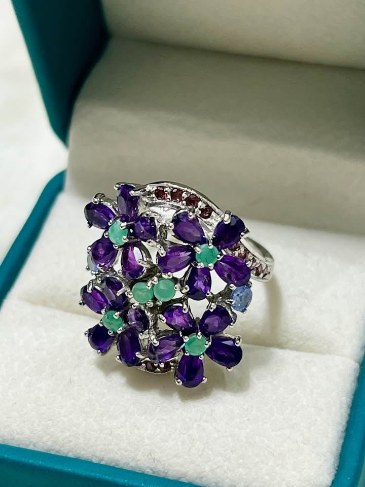 Natural amethyst and emerald floral cluster ring in sterling silver, vibrant purple and green.