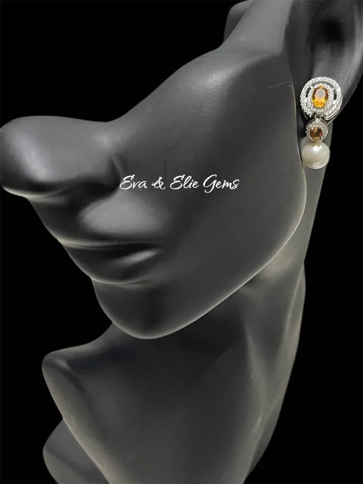 Dangle earring on a mannequin, showcasing natural sterling silver with oval citrine, small citrine, and pearl.