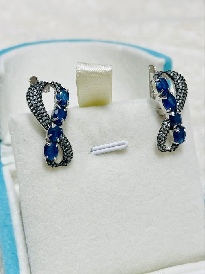  Stunning sterling silver infinity earrings adorned with natural sapphires.