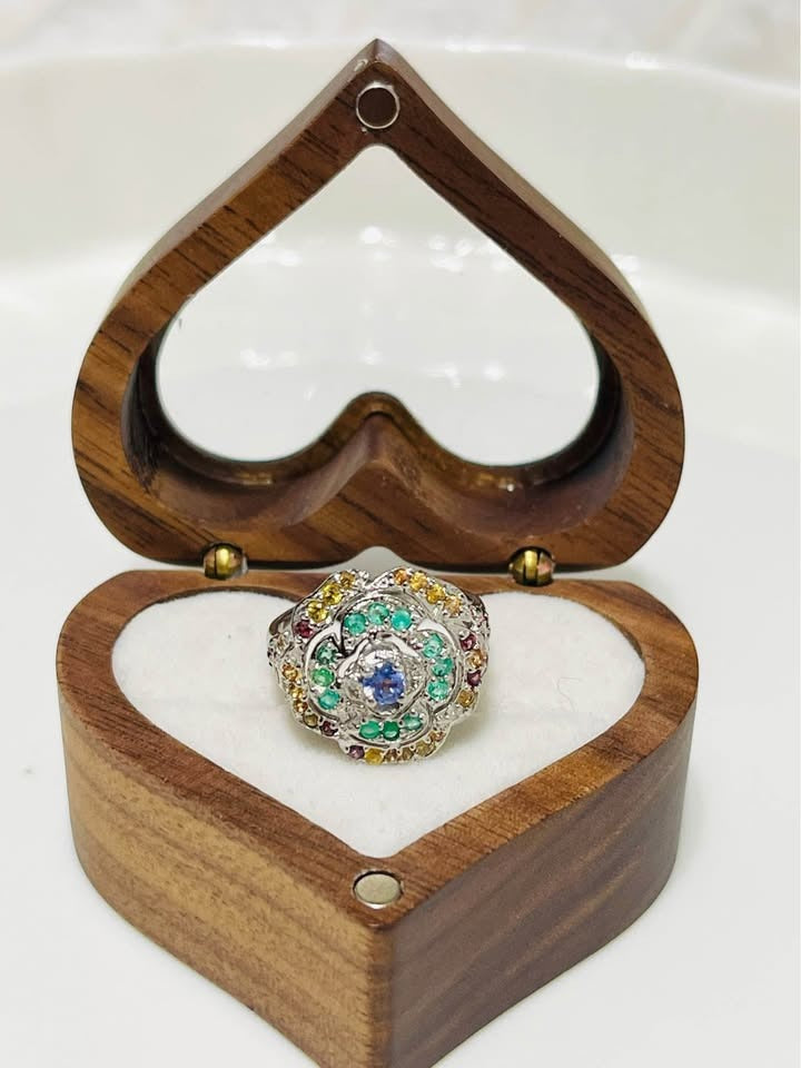 Sterling silver ring with peridot, emerald, and tanzanite in a heart-shaped wooden box. A multi-gemstone masterpiece.