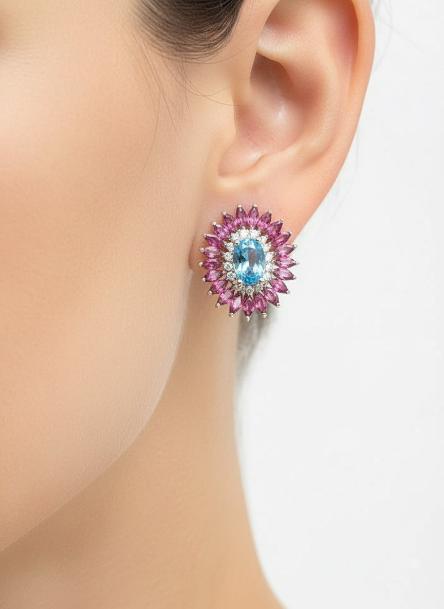 Swiss blue topaz and rhodolite garnet earring in silver, worn on an ear mannequin.