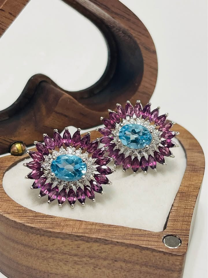 Stunning Swiss blue topaz and rhodolite garnet earrings displayed in a heart-shaped wooden box.