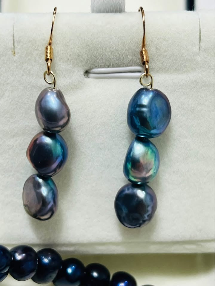 Detailed view of natural Tahitian black pearl drop earrings, showcasing their dark, multi-tonal sheen.