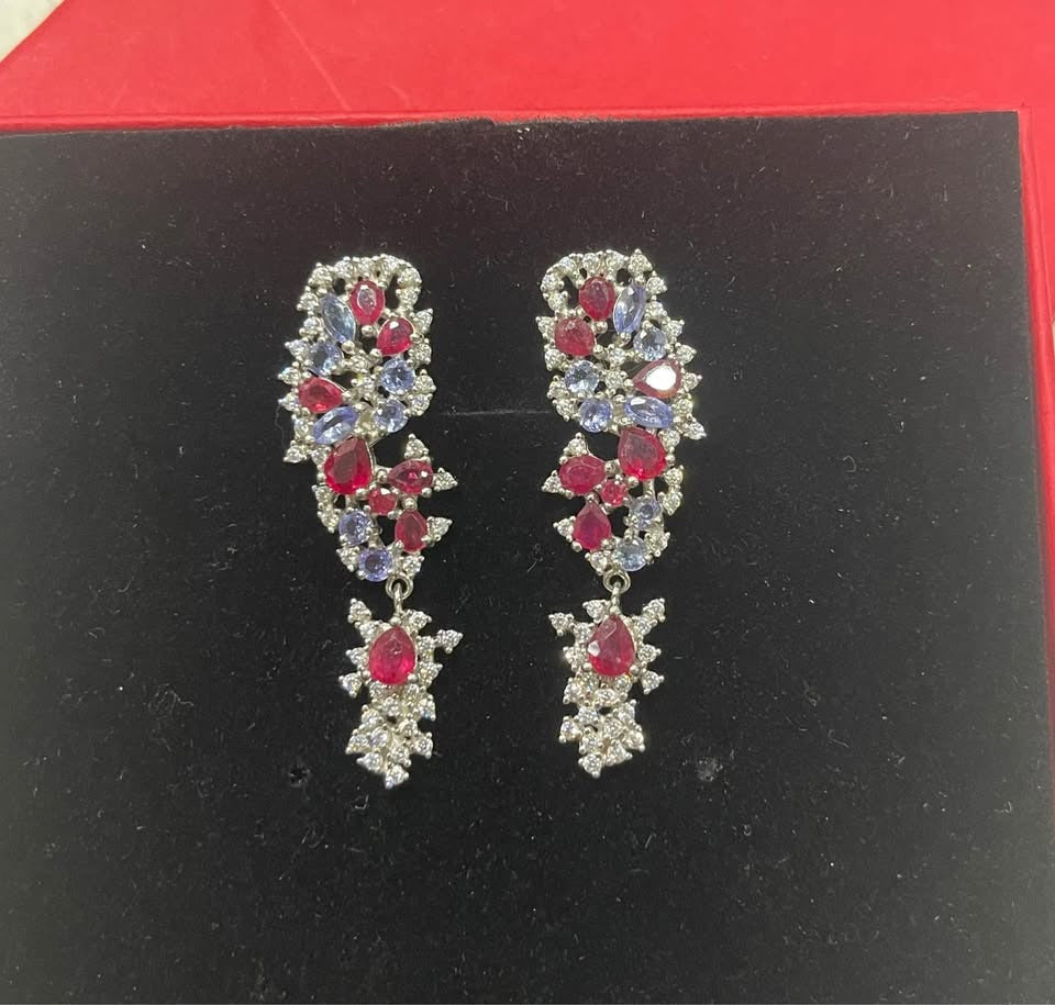  Tanzanite and ruby cluster drop earrings with diamond accents, displayed in a red jewelry box.