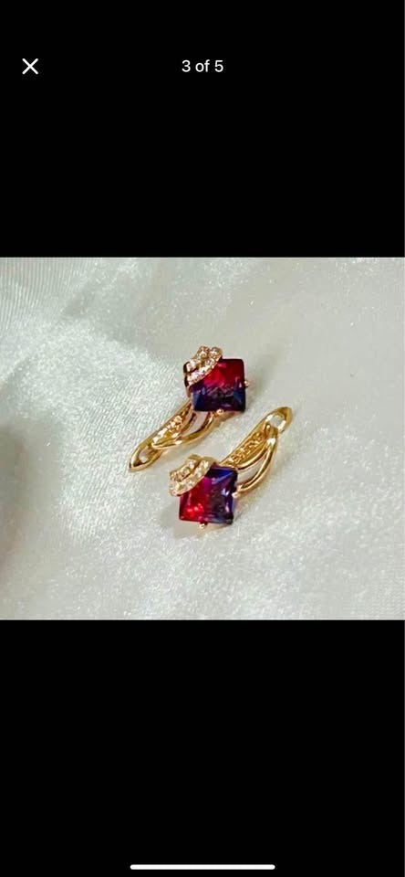 Close-up of two-tone tourmaline earrings. Detailed rose gold setting with sparkling accent stones.