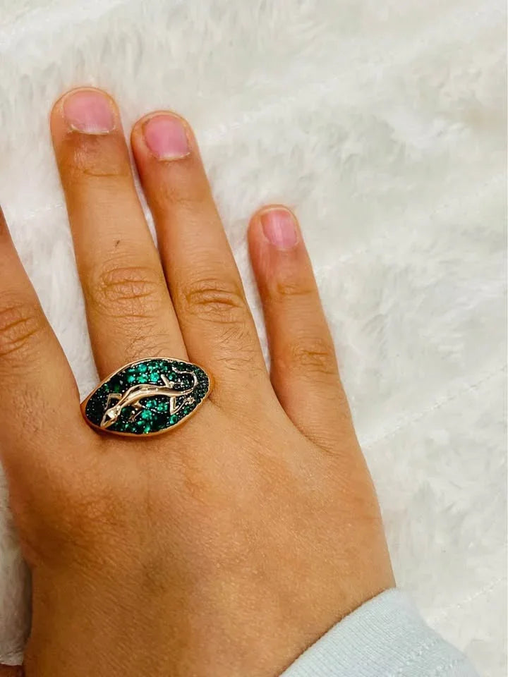 Unique 585RG stamped rolled gold salamander ring with green stones, elegantly displayed on a hand.