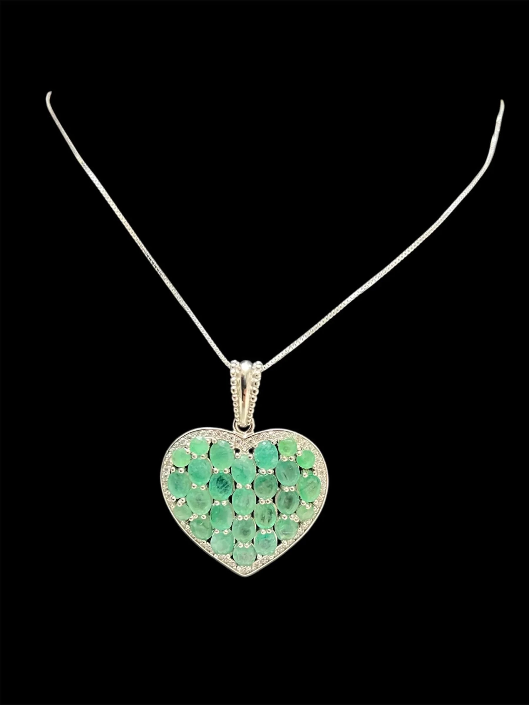 Sterling silver heart pendant with vivid untreated Colombian emeralds and diamond accents.