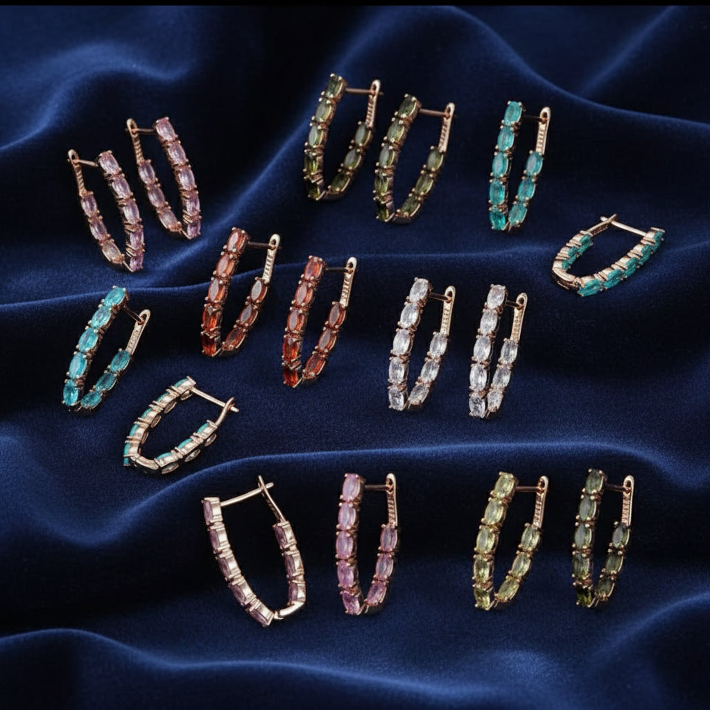 A variety of 14k gold-filled "V" shaped inside-out hoop earrings, with multi-colored baguette-cut tourmaline stones.