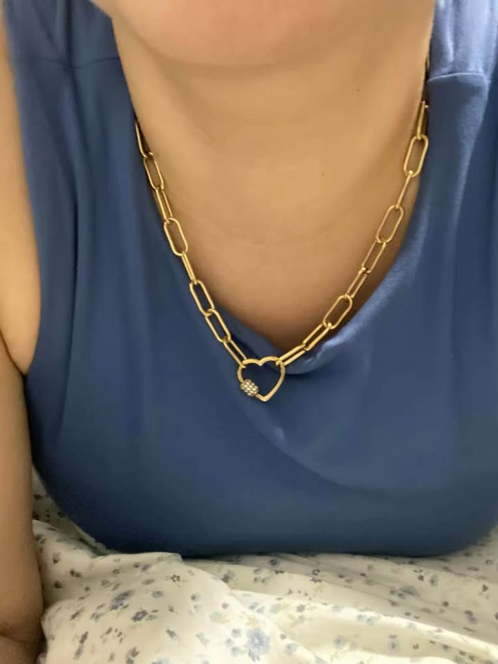Model wearing a vermeil paperclip chain necklace with a pave heart clasp and sparkle.