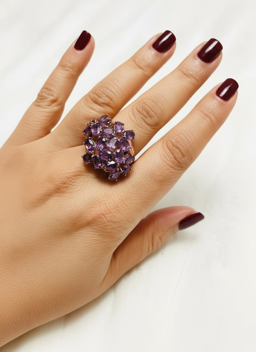 Bold amethyst multi-stone rose gold cocktail ring, elegantly worn on a hand.