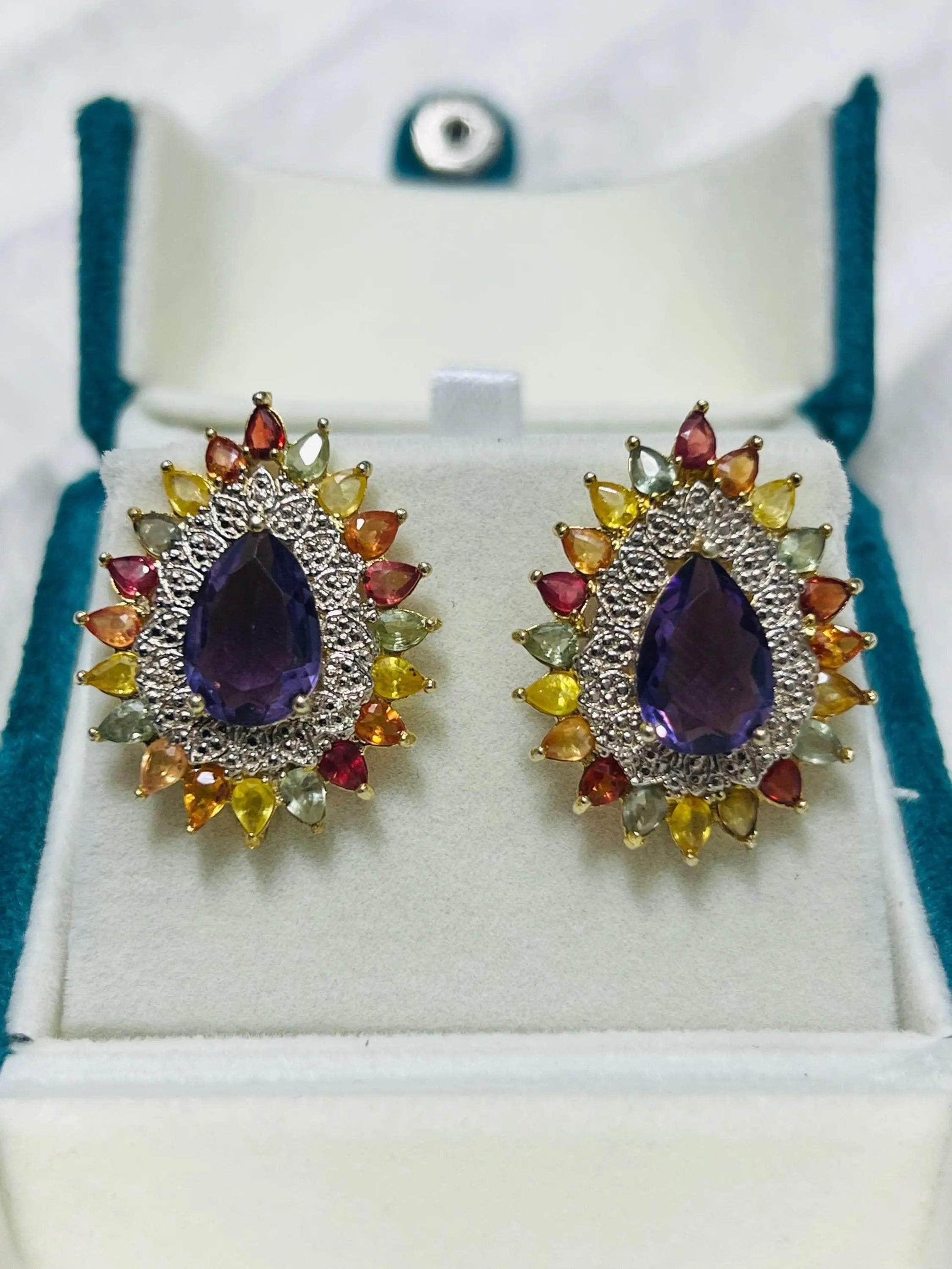 Pair of handmade amethyst and multi-color sapphire sunburst earrings in a jewelry box, full front view.