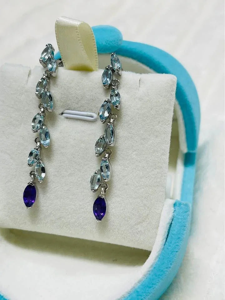 Natural aquamarine and amethyst dangle earrings with a marquise-cut design, displayed in a jewelry box.